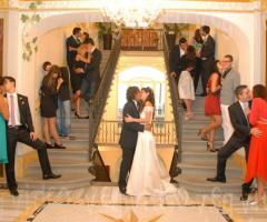 Gli sposi e gli invitati in posa per una foto divertente e romantica