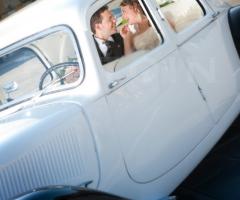 Foto degli sposi sorridenti nella macchina da cerimonia