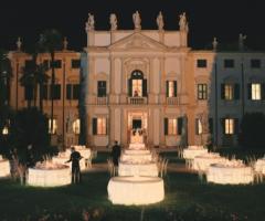 Tavoli illuminati al cospetto della villa per matrimoni