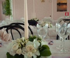 Centrotavola con rose e candele per il ricevimento nuziale