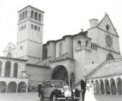 Foto sposi accanto all'auto degli sposi