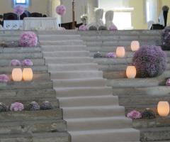 Composizione floreale lilla con sfere di fiori e candele