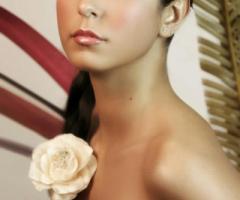 Acconciatura per la sposa con treccia di lato e fiore