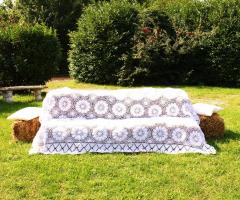 Divanetto realizzato con balle di fieno e coperta in pizzo