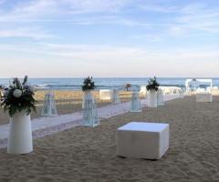 Decorazioni floreali con vasi di design per un matrimonio in spiaggia