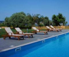 Ampia piscina immersa nel verde presso l'hotel Feudo Bauly