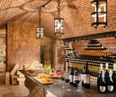 La Cantina della Tenuta: volte a botte sorrette dalle ruvide pietre di Prun, ferro battuto  frutto del lavoro degli artigiani della contrada del ferro e tante bottiglie.