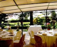 Tavoli allestiti per un ricevimento di matrimonio a contatto con la natura