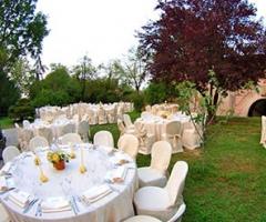 Tavoli allestiti per il ricevimento di nozze nel giardino del castello