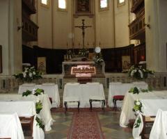 Allestimento con tessuti bianchi per i banchi della chiesa