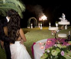 Gli sposi durante il taglio della torta con fuochi d'artificio