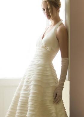 Abito da sposa con guanti lunghi e balze sulla gonna