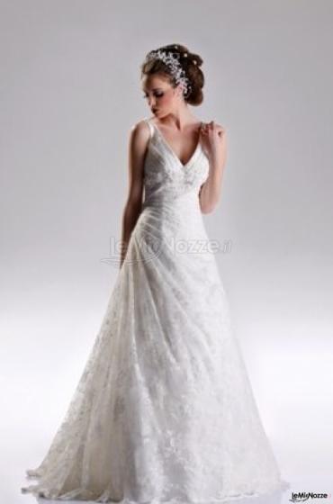 Abito da sposa dalla linea semplice, ricoperto da un importante velo ricamato