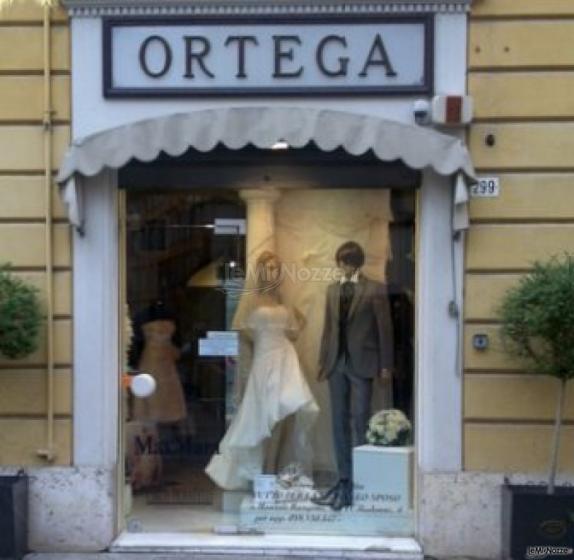 Pregiati abiti da sposa e da sposo esposti nella vetrina dell'Atelier Ortega Sposi